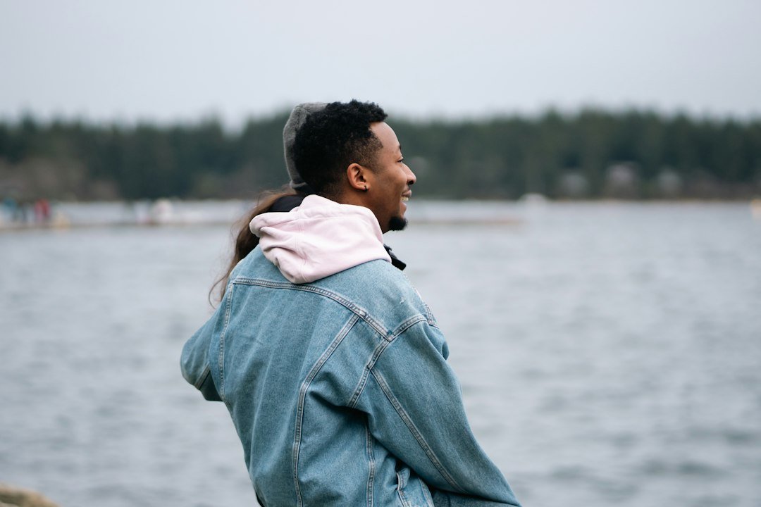 Stylish man outdoors by a lake, showing a glow up