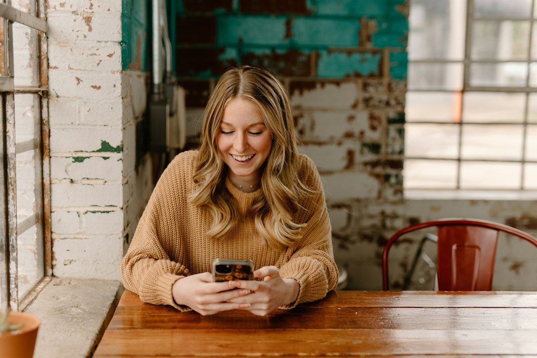Woman smiling while reading a text message on her phone