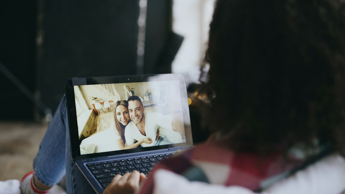 Woman on a video call with her partner on a laptop outdoors