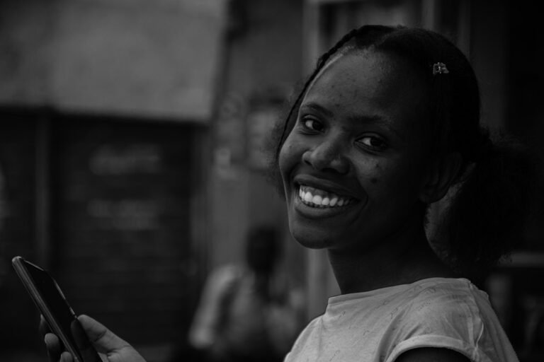 Woman smiling while reading a text message on her phone
