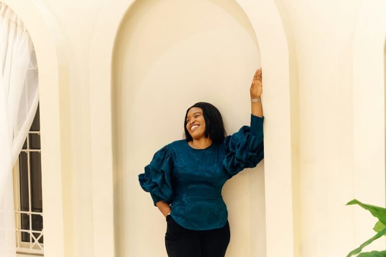 Confident woman leaning against a wall with her arms crossed
